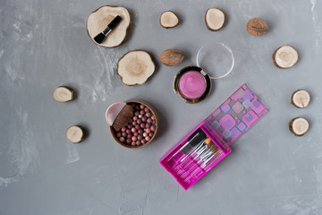  A set of pink makeup brushes with blush on a gray phon