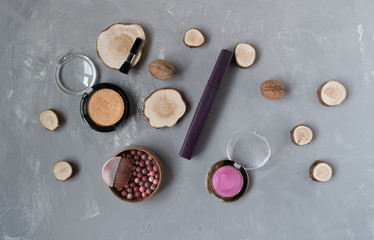  Makeup set on a gray background among the round wood
