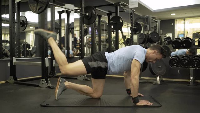 Image of a muscular man doing leg exercise at the gym.