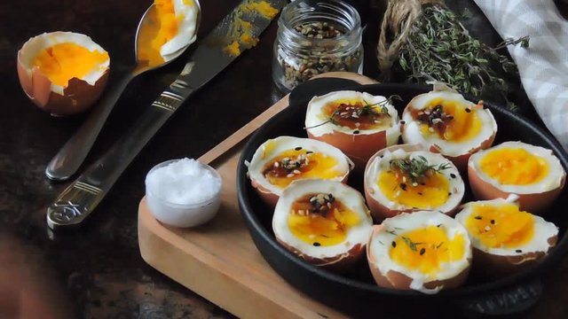 Soft-boiled eggs in the shell in a cast iron skillet.