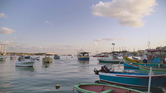 Unusual eyed colourful boats Luzzu swinging in rapide near the fishing village Marsaxlokk, Malta