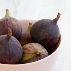Fresh figs in a pink bowl, side view. Close-up. Selective focus.