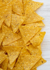 Tortilla chips on white wooden background, overhead view. Mexican food. Flat lay, from above, top view.