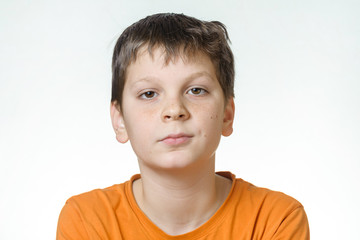 Portrait of a boy - a teenager on a white background, close-up, emotion, boredom, doubt