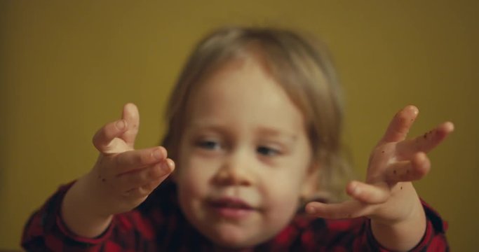 Toddler at dinner table showing food hands