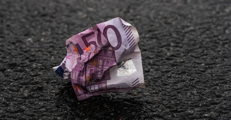 Zerknitterter Fünfhundert Euroschein auf Asphaltstraße