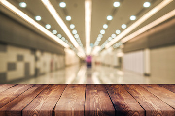 wood table on blur shopping mall, department store, mall  background - can used for display or montage your products