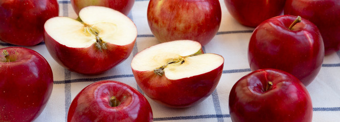 Fototapeta na wymiar Fresh raw red apples on cloth, low angle view. Close-up.