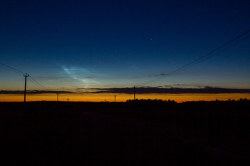 Fototapeta na wymiar Noctilucent clouds. A comparatively rare atmospheric phenomenon, extremely rarefied clouds, appearing in the mesosphere under the mesopause and visible in deep twilight.