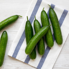 Fresh raw green cucumbers on white wooden table, top view. Flat lay, from above, overhead.