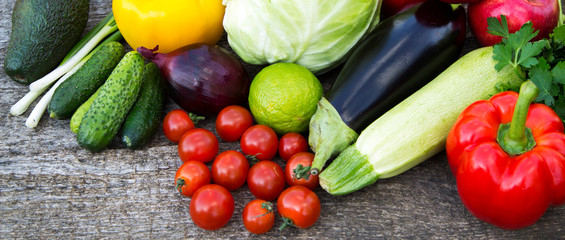 Collection of fresh organic fruits and vegetables on rustic wooden background, overhead. Top view.