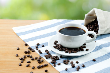 cup of coffee and beans on wooden table