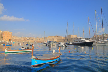 Fototapeta na wymiar Boats and yachts moored in the harbor of Malta on a quiet morning.