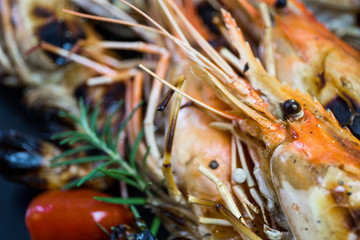 Grilled orange shrimp on a black plate