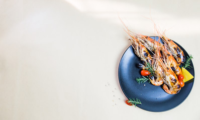 Grilled orange shrimp on a black plate