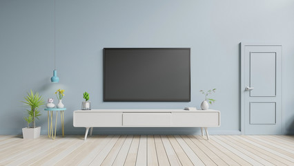 Obraz na płótnie Canvas TV on the cabinet in modern living room have plants and book on blue wall background,3d rendering