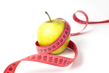 Green apple and measuring tape on white background
