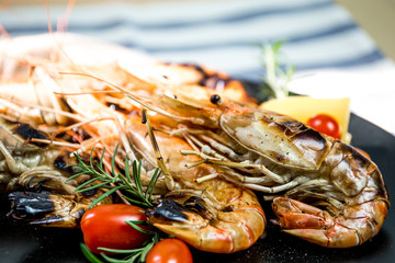 Grilled orange shrimp on a black plate