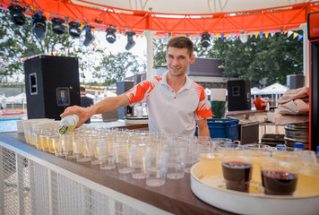 Bartender pouring and serving alcoholic drinks at bar 