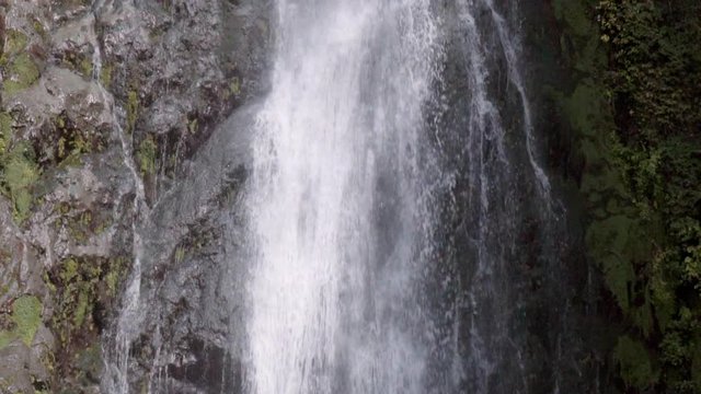 Slow Motion: Panning Up Steep Waterfall from Pool at the Bottom to the Top