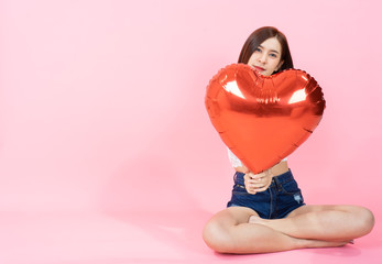 Asian young woman in white bra  red balloon heart. Young woman holding it with  being excited and surprised  holiday present isolated white  background.concept love surprise valentine day..