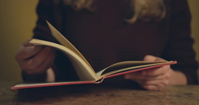 Young woman flipping through pages of book