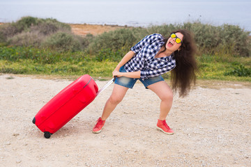 Travel, tourism and people concept - happy emotional young woman going to travel by car with two huge suitcases
