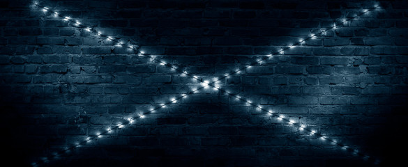 Old brick wall, dark room with brick wall, rays of searchlight light, illuminated night lights on an empty wall. Dark street, night city.