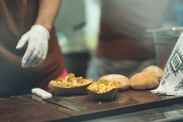 cheesy jalapeno skillet potatoes fries with cheddar and jalapenos on the food truck table at the street food festival at night ready to be served