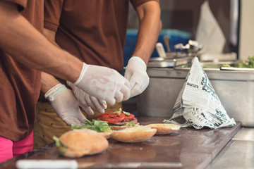 chefs cooking delicious fresh burger in the food truck van at the street food festival for the food market meat cuisine