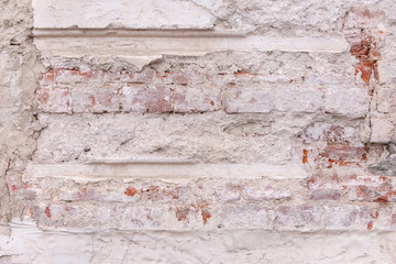 Old Weathered Brick Wall With Beaten Pieces Of Whitewash, Putty And Plaster. Fragment Of Wall Surface Of Historic Building With Chips, Cracks And Damages.