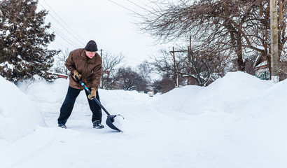 Man with a shovel cleans the track from the snow	