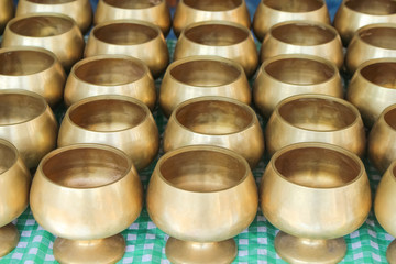 Row of empty gold monk's bowl or almsbowl in thai temple