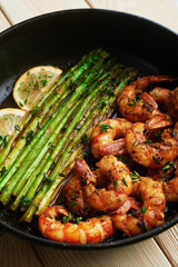 fried langoustines with asparagus decorated with lemon slices. roasted king prawns tiger shrimps with green garnish