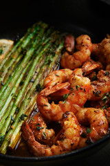 fried langoustines with asparagus decorated with lemon slices. roasted king prawns tiger shrimps with green garnish