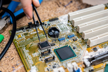 person conduct scientific research on electric circuit with tweezers b