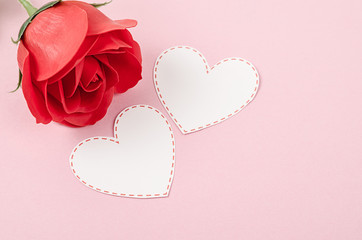 Blank card heart shape with red rose on pink background.