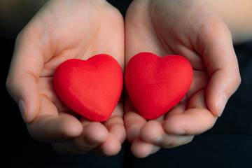Female hands giving red hearts