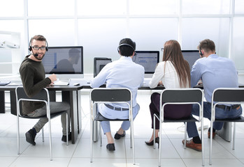 rear view.a group of employees sitting at a Desk in the business center