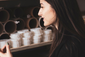 young pretty girl, student, hipster, doing a startup, working in an office or library, browsing dusty shelves with cardboard boxes in typography