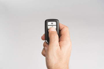 Hand of man holding and push remote control of car isolated on gray background