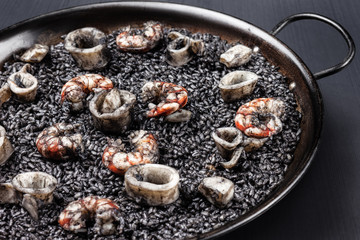 Black rice with sea food / Creative concept photo of  sea food and black rice on plate on black background