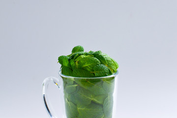 Mint leaves in a cup isolated on white background.