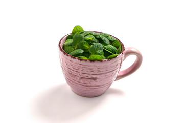 Mint leaves in a cup isolated on white background.
