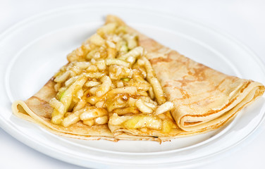 Thin delicious pancake with apple on white