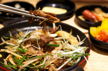 Asian cuisine, pan with meat close up, top view