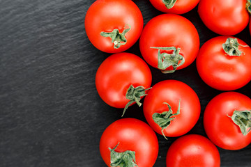 ripe tomatoes on slate background