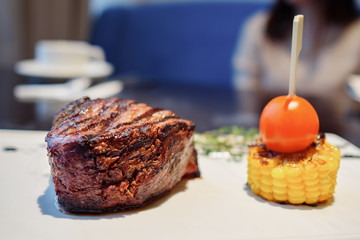 Close up of delicious juicy meat steak and vegetables on white plate, selective focus