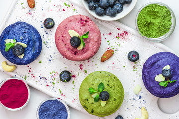 healthy vegan desserts. assortment of raw cashew cakes with matcha, acai, blueberry, mint and nuts....