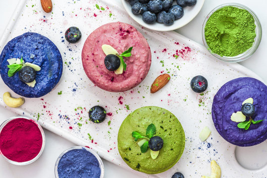 Healthy Vegan Desserts. Assortment Of Raw Cashew Cakes With Matcha, Acai, Blueberry, Mint And Nuts. Gluten Free Diet